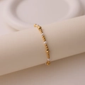 Detailansicht der 18K vergoldeten Perlen und weißen Süßwasserperlen am elastischen Armband - Abwechselnde Goldperlen und Perlen-Stil