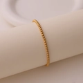 Nahaufnahme eines minimalistischen vergoldeten Perlenarmbandes auf weißem Ständer - Glatter Goldperlen-Stil