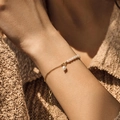 Detail view of 18K gold-plated chain bracelet with natural freshwater pearls on model - Gold Pearl Bracelet