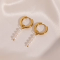 Detailed close-up of gold stainless steel pearl drop earrings on white silk fabric - Four-Pearl Vertical Style (Style 09)