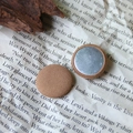 Close-up of round khaki fabric covered buttons with silver metal back on vintage paper - Light Coffee