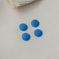 Nahaufnahme von vier leuchtend blauen Stoffknöpfen für DIY-Näharbeiten auf hellem Hintergrund - Blau