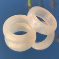 Set van twee parelmoer witte hars ringen met subtiele glinstering op blauwe reflectie - crème