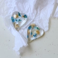 Macro detail of heart resin pendant with gold foil and blue dried flowers for DIY jewelry - Blue