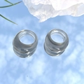 Minimalist transparent resin rings set reflecting blue sky on a mirror surface - Smoke