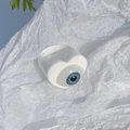 Close-up of a white resin ring featuring a blue heart-shaped eye for DIY jewelry making - White