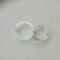 Macro shot of two minimalist transparent resin rings on a beige ceramic plate - Clear White