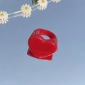 Glanzende rode hartring van hars op een spiegel die de helderblauwe lucht reflecteert - Rood
