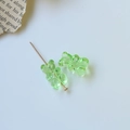 Detail view of light green resin gummy bear charms with golden pin for DIY jewelry making - Green