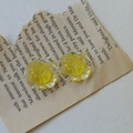 Nahaufnahme gelber Harzrosen-Ohrringe im Vintage-Stil auf antikem literarischem Papier - Gelb