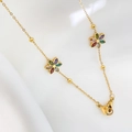 Goldene Titanstahl-Blumenhalskette mit bunten Kristallen auf weißem Seidenhintergrund - Gold