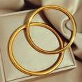 Brazaletes minimalistas clásicos dorados sobre un lujoso estuche de seda y cuero - Espejo Moda / 56mm