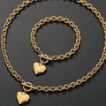 Ensemble collier et bracelet avec pendentif cœur doré et fermoir OT sur fond noir - Bracelet Or