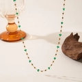 Detailed close-up of a long gold chain necklace with green faceted beads and metal spacers - Green Zirconia Square Necklace (QYH1062) / Gold