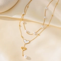 Elegant gold double layer pearl necklace with heart pendants on a silk background - Double Heart Chain (H1224) / Gold