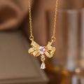 Collier doré avec nœud papillon, pierre de cœur rose et pendentif goutte étincelant - Noeud Goutte d'eau (9095)