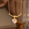 Vue macro du collier doré avec pierre rose en forme de cœur et petits diamants brillants - Coeur Noué (9100)