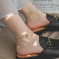 Detail eines 14K vergoldeten Fußkettchens mit zwei Kugelanhängern und schicken Schuhen - Doppeltes Goldperlen Fußkettchen (Gold)