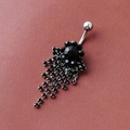 Dangle flower belly ring with black crystals and silver tassels on a textured surface - Black