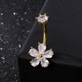 Macro view of gold floral belly ring with pear-shaped cubic zirconia on black box - Gold Flower
