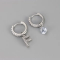 Detail van zilveren asymmetrische oorbellen met kristallen letter F en een druppel - Koper / Zilver-Letter F