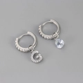 Macro-opname van asymmetrische zilveren oorbellen met letter G en peer-cut zirkoon - Koper / Zilver-Letter G