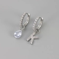 Detail van asymmetrische zilveren oorbellen met letter K en peervormige zirkonia hanger - Koper / Zilver-Letter K