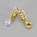 Detail van asymmetrische gouden oorringen met druppel zirkoon en pavé kristallen bedels - Koper / Goud-Letter O