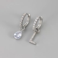 Detailweergave van asymmetrische oorbel met letter L en zirkonia druppelvorm - Koper / Zilver-Letter L