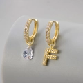 Macro-opname van asymmetrische vergulde oorbellen met druppelvormige zirkoon en letter F-hanger - Koper / Goud-Letter F