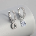 Detail van asymmetrische zilveren oorbellen met peergeslepen zirkonia en micro-pave kristallen - Koper / Zilver-Letter O