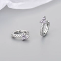 Close-up of silver earrings with purple floral zircons and white pave stones on gray - White Gold Purple Zirconia