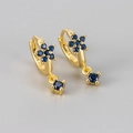 Detail view of flower-shaped earrings with blue zircon and S925 sterling silver hallmark - Gold/Blue