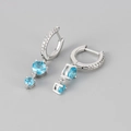 Détail macro de boucles d'oreilles en argent S925 avec zircons bleus et fermoir sûr - Couleur Platine / Strass Bleu