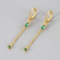 Dettaglio di orecchini pendenti dorati con gemme verdi e catena a maglie sottili - Orecchino a Bottone con Nappina a Goccia d'Acqua / Oro / Zircone Verde