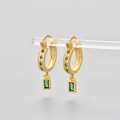 Detail of gold huggie earrings featuring a green star stud and rectangular gemstone drop - Gold/Green Zirconia