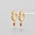 Detailed view of gold hoop earrings with starburst patterns and pink rectangular gemstones - Gold/Rose Red Zirconia