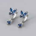 Detail of silver butterfly earrings featuring deep blue marquise stones and round drop pendants - White Gold / Blue Zirconia