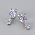 Detailed macro of silver butterfly earrings with purple zircon stones and drop design - Silver Tone/Purple Zirconia