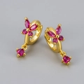 Detailed close-up of golden butterfly hoop earrings with vibrant magenta zircon stones - Gold / Rose Red Zirconia