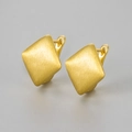 Macro shot of geometric square earrings featuring premium brushed gold metal texture - Gold