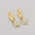 Detailed close-up of gold hoop earrings with crystal-encrusted letter H pendants - Gold / H