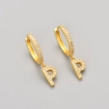 Detailed close-up of golden letter P hoop earrings with sparkling white cubic zirconia - Gold / P