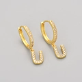 Macro shot of gold U-shaped drop earrings featuring shimmering micro-pave zircon stones - Gold / U