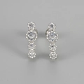 Close-up of silver stud earrings with four graduated round cubic zirconia stones - Platinum White Zirconia