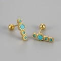 Macro shot of S925 silver gold-plated stud earrings with green turquoise stones - Gold Blue Zirconia