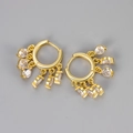 Detail of gold huggie earrings with five dangling clear cubic zirconia stones and macro view - White Zirconia Tassel Huggie