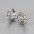 Macro shot of silver hoop earrings featuring four round inlaid opal gemstones - Small / Silver - White