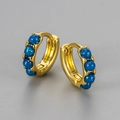 Macro detail of gold huggie earrings featuring inlaid round blue opal-like stones - Small / Gold-Blue
