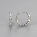 Detailed macro view of S925 silver hoop earrings with shimmering white opal stones - Medium / Silver - White